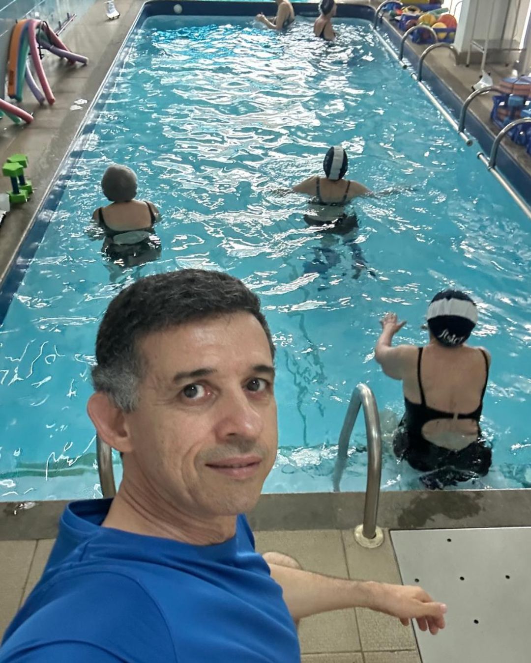 Dr. Rogério Ferreira na borda da piscina da Fisior Hidroterapia, com uma sessão em andamento